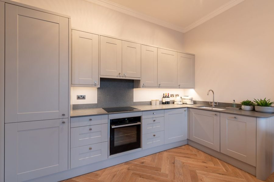 Fitted grey shaker kitchen with integrated oven and hob