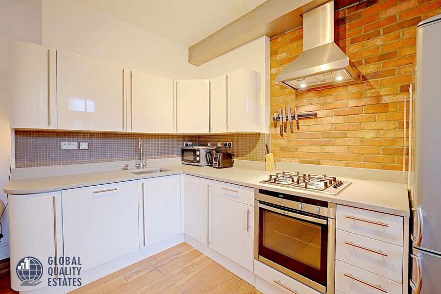 Kitchen with gas hob and exposed brick splashback