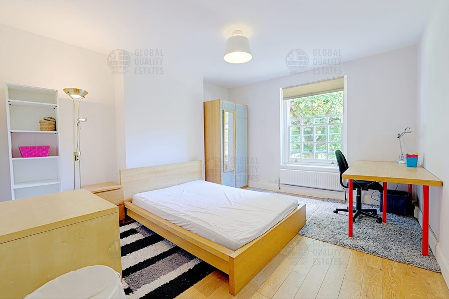 Principal bedroom with bookshelf unit and desk