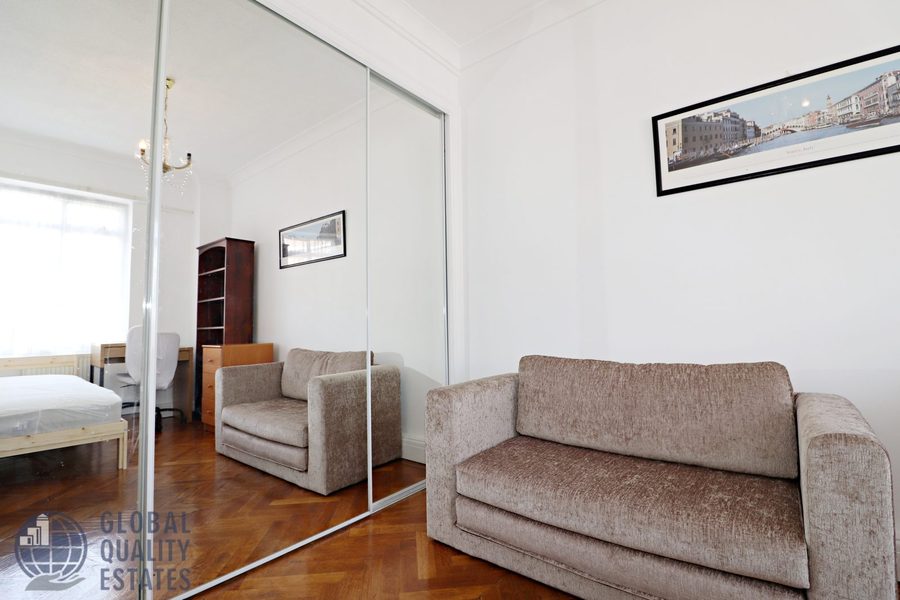 Bedroom with sofa and mirrored wardrobe